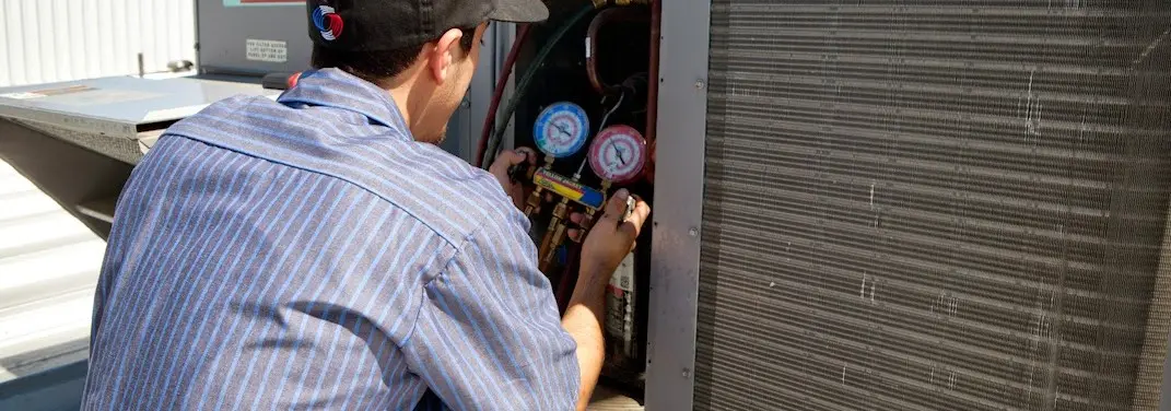 HVAC technician servicing a condenser unit in Cypress