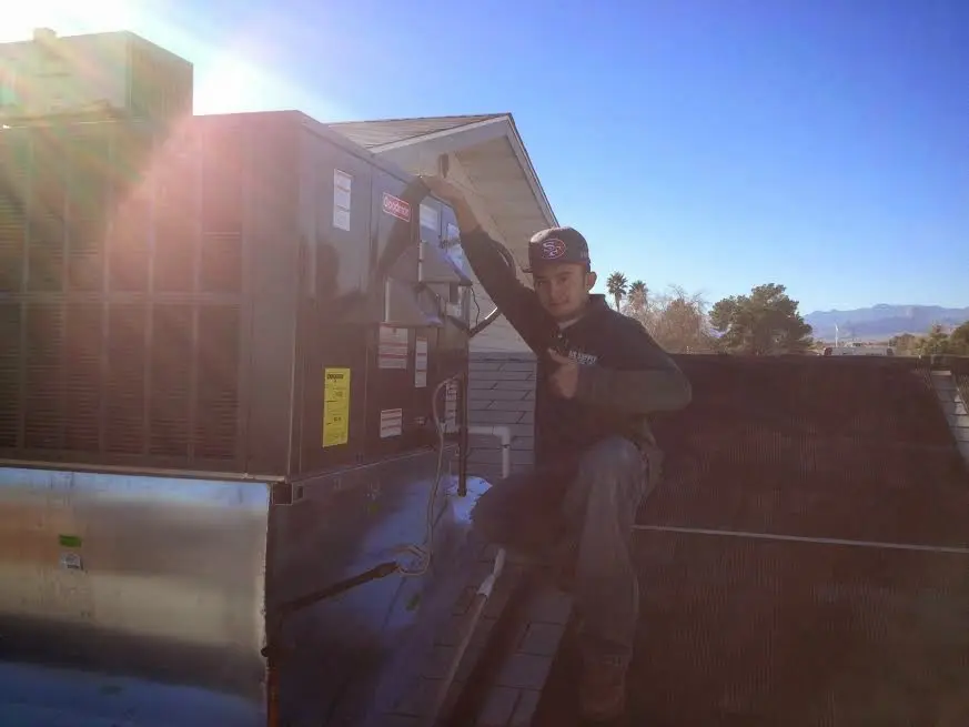 HVAC technician performing AC Tune-Up on a rooftop unit in Cypress